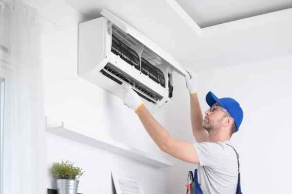 A technician fixing a split AC unit from Cristal Air Conditioning in Round Rock, TX